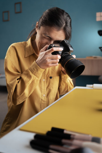 摄影师在家庭工作室的桌子上拍摄美容产品。专业摄影、现代艺术及创作事业图片下载