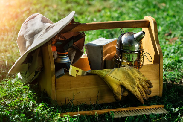 养蜂设备。养蜂人的工具。养蜂人和蜜蜂一起工作的一切。烟熏器，凿子，盒子，防蜜蜂的养蜂人服。以养蜂为主题的照片。图片下载