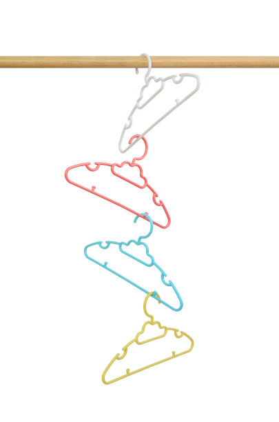 白色背景下的木制晾衣绳上的彩色塑料衣架。图像与剪辑路径图片下载