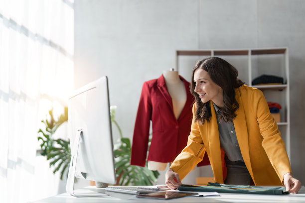 年轻的设计师测量纺织材料，工作室车间图片下载