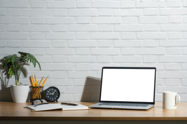 笔记本电脑的空屏幕，笔筒，咖啡杯和室内植物在木桌上。图片下载