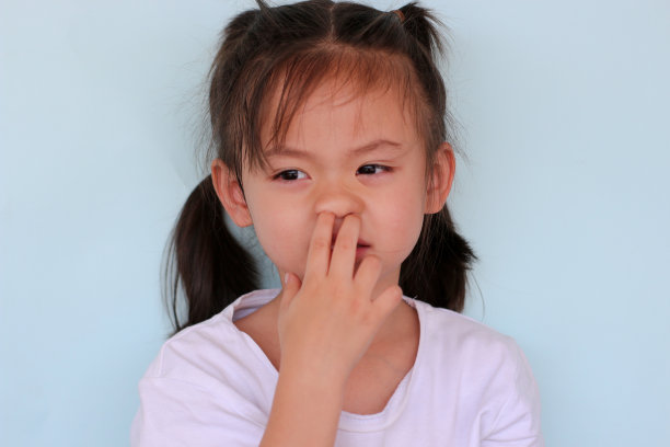 女孩用手捂住鼻子做手势。图片下载