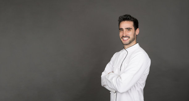 年轻的男厨师对着镜头微笑图片下载