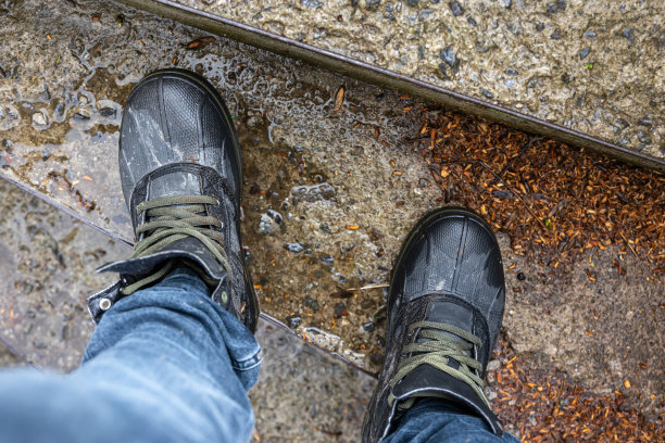 从上面看，一双徒步鞋陷在泥里。图片下载