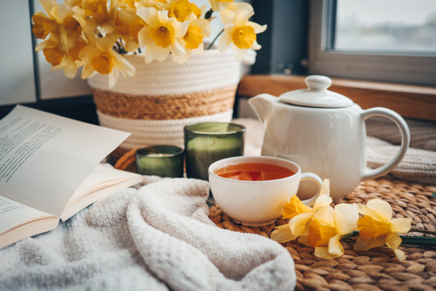 一杯茶，蜡烛，打开的书，篮子里放着水仙花，春天的唯美照片图片下载