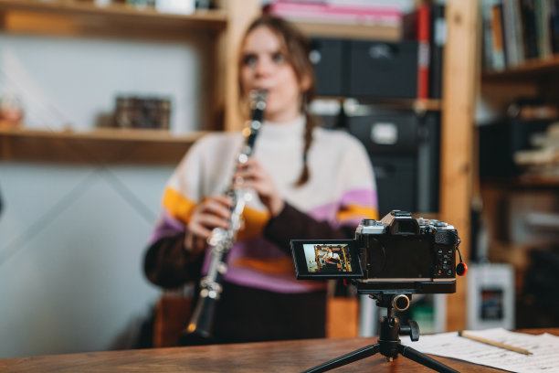 一位音乐家一边吹单簧管一边录制视频图片下载