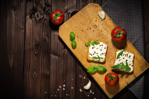 早餐照片的奶油奶酪和面包切片在木制背景。图片下载