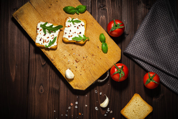 早餐照片的奶油奶酪和面包切片在木制背景。图片下载