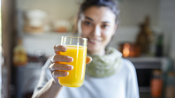 喝橙汁的年轻女子图片下载