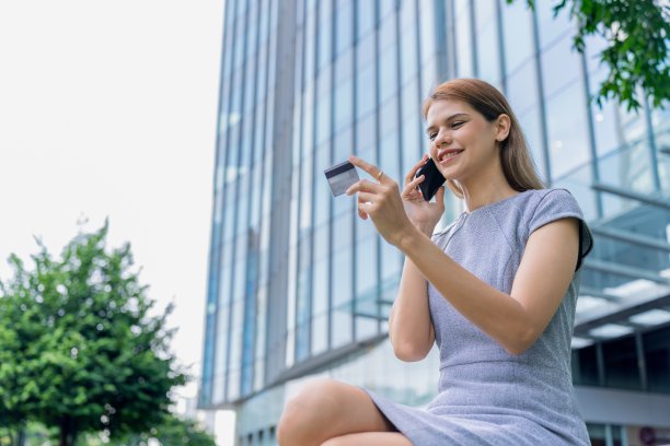 漂亮的女商人用她的手机和信用卡在网上预订旅行图片下载