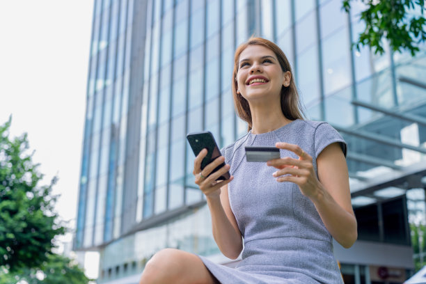 漂亮的女商人用她的手机和信用卡在网上预订旅行图片下载