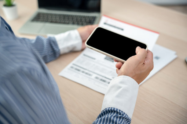 商人在收到发票后，用手机扫描条形码支付每月的信用卡账单。网上缴费概念图片下载