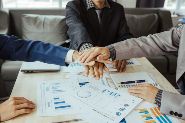 俯视图，年轻的商人在握手。一堆手。团结和团队合作的理念。图片下载