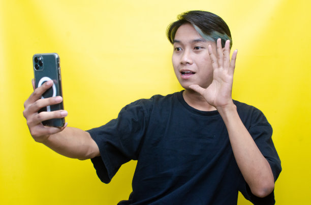 亚洲男子拿着手机用无线耳机听音乐图片下载