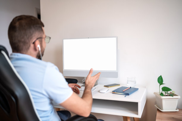 一个人在办公桌前工作，用电脑打视频电话。图片下载