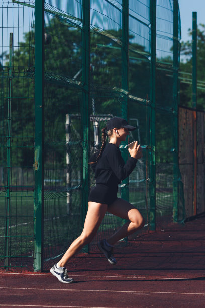 小女孩正在体育馆里一边慢跑一边听音乐。图片下载