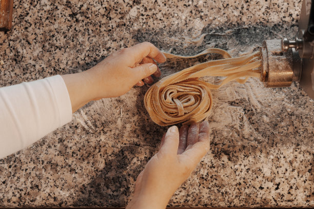 农作物女厨师用机器制作意大利面并擀面图片下载