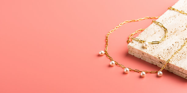 时尚的金色珠宝与珍珠在粉红色的背景。图片下载