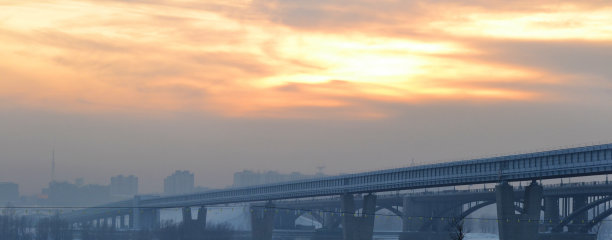 黄昏的城市，城市建筑映衬着天空，空气污染，生态恶劣，铁路桥梁图片下载