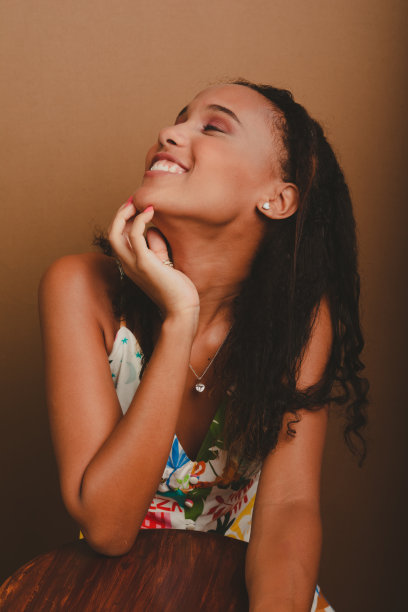 一个漂亮的十几岁的女孩倚在木凳上，双手放在下巴上。图片下载