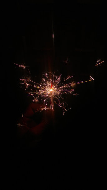 烟花在黑暗中闪烁着光芒，看起来美丽迷人。图片下载