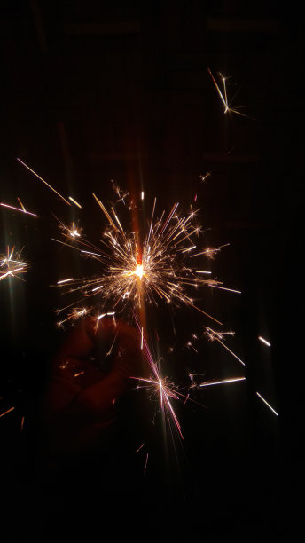 神奇的!烟火的火花。在黑暗中产生明亮光环的烟火图片下载