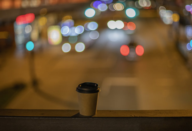 咖啡杯，街上的外卖纸，虚化的背景图片下载