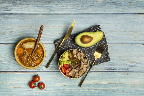 头顶上的一张静物照片是菜单，第一道菜是西红柿和金枪鱼沙拉，浅蓝色的桌子上放着一些炖扁豆图片下载