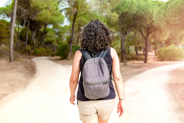 女人在森林里选择光明的路还是黑暗的路。人生决策的概念。图片下载