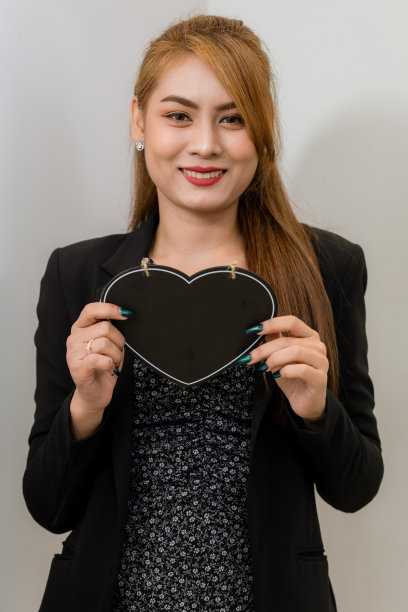 在现代办公室里拿着黑板的女商人。漂亮的女商人在明亮的现代办公室里拿着黑板图片下载