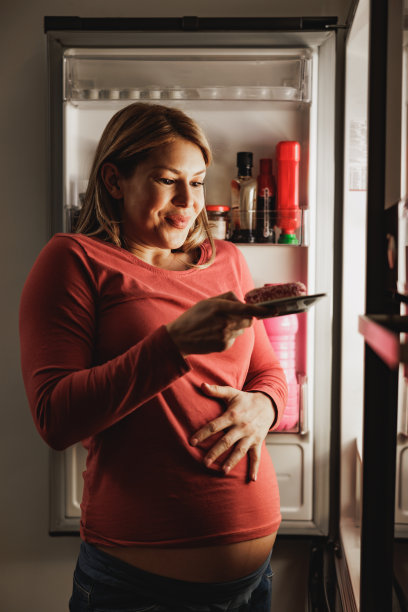 怀孕的女人晚上吃甜甜圈图片下载
