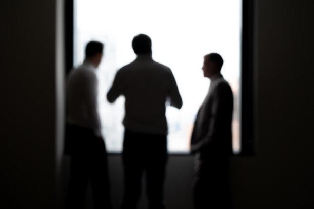 清晨，商务男人在高楼暗室内交谈的剪影图片下载