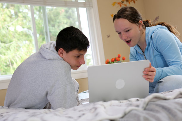 教育，人，科技，学习理念快乐的高中生在卧室使用笔记本电脑图片下载