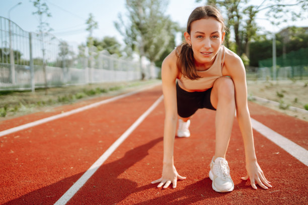 精力充沛的妇女在运动场上做运动。健康生活方式的概念。体育训练。图片下载