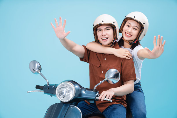年轻的亚洲夫妇骑摩托车的背景图片下载