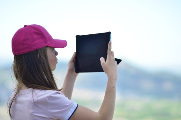 一个女孩用平板电脑拍照图片下载