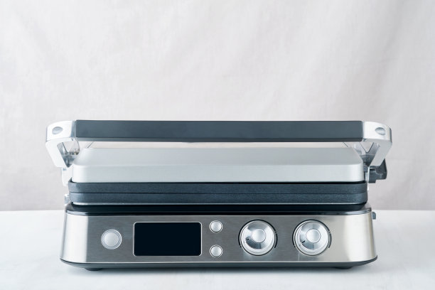 电动烧烤。现代厨房便携式烧烤工具为现代厨房烧烤肉类，蔬菜和零食的晚餐或聚会在浅灰色的背景。放文字或广告的地方。模拟。图片下载