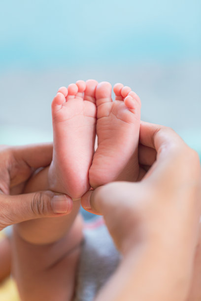 宝宝的脚，宝宝的脚在手里，妈妈，妈妈和她的宝宝，幸福的家庭观念，美丽的受孕形象分娩。图片下载