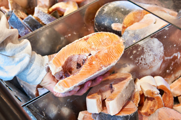 买家手里拿着冻红鲑鱼图片下载