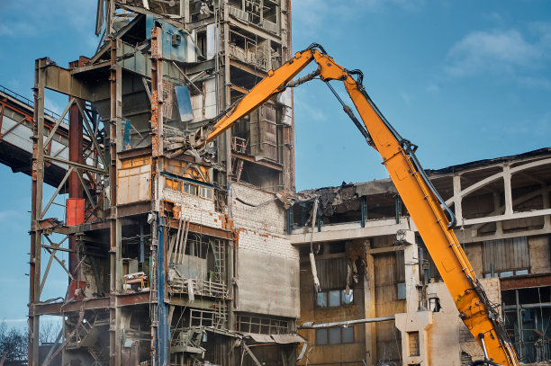 挖掘机驱逐舰对旧工业建筑的破坏图片下载
