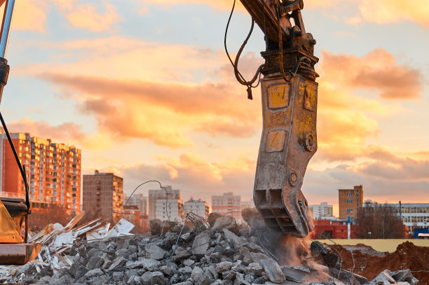 混凝土破碎机工作与一堆水泥石的特写图片下载