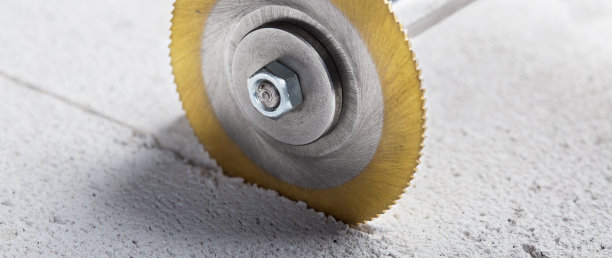 涂有金刚石涂层的金属锯、立铣刀或钻头在混凝土板上打孔。工业和建筑业。图片下载