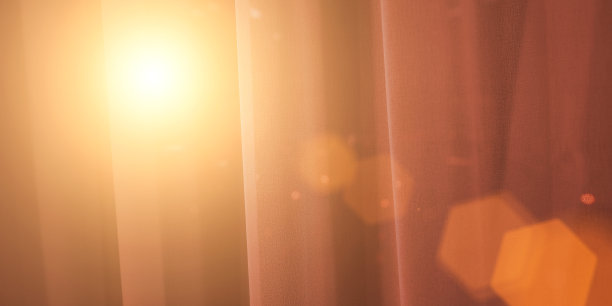 黎明时分，明亮的阳光透过窗户上透明的窗帘照进来。图片下载