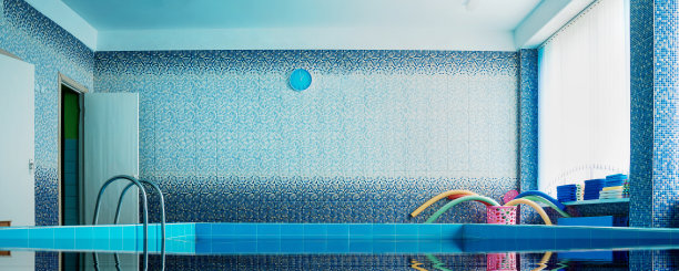 空的室内游泳池场地，水面和瓷砖墙图片下载