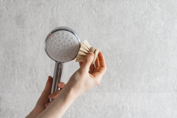 用毛刷清洁镀铬淋浴喷头图片下载