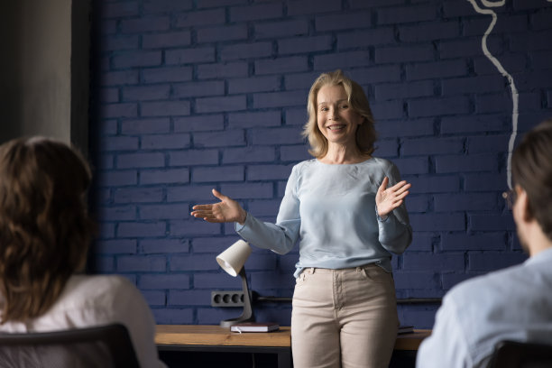 友好积极的资深企业女教师在小组前发言图片下载