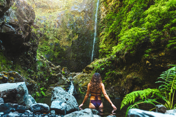 在马德拉雨林风景如画的瀑布旁，一名穿着比基尼的女游客在泳池里享受清爽的沐浴。欧洲葡萄牙马德拉岛caldeir<e:1> o Verde的勒瓦达。图片下载