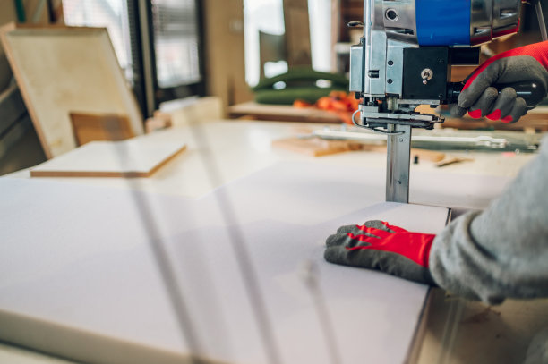 一个泡沫切割机和工匠的手在车间操作的裁剪图片。图片下载