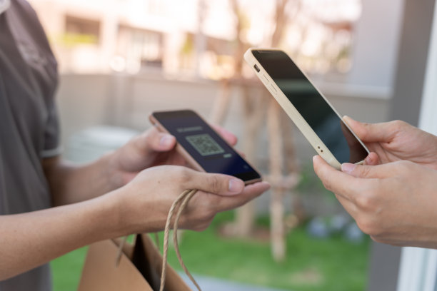 快乐的微笑亚洲女人扫描二维码支付食物。快递员送快递。网店、纸盒、外卖、邮差、快递服务、包裹、电子货币、数字转账图片下载