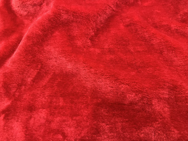 红色天鹅绒的背景或纹理。近距离红色天鹅绒纺织品背景与复制空间。图片下载